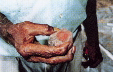 image of hands holding piece of red ochre rock